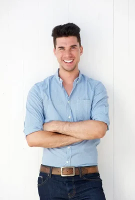 happy-young-man-smiling-against-white-background-portrait-32435252